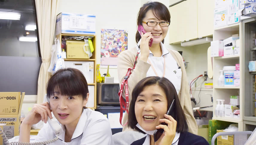 笑顔で電話をする看護師達の写真